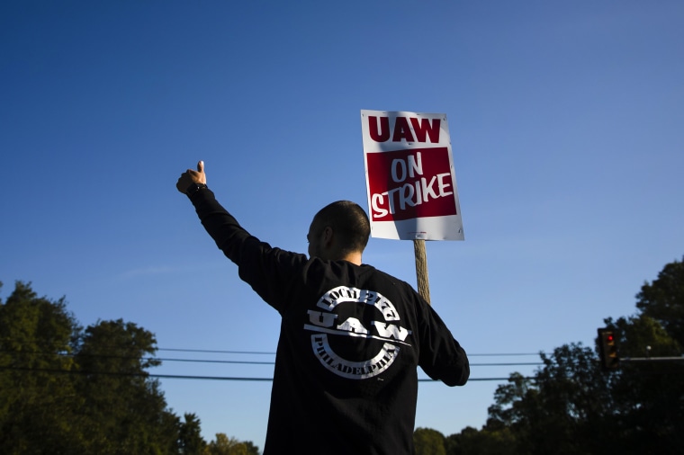 Image: A worker gestures to passing motorists outside of the General Motors facility in Langhorne, Pa., during a United Auto Workers strike on Sept. 17, 2019.