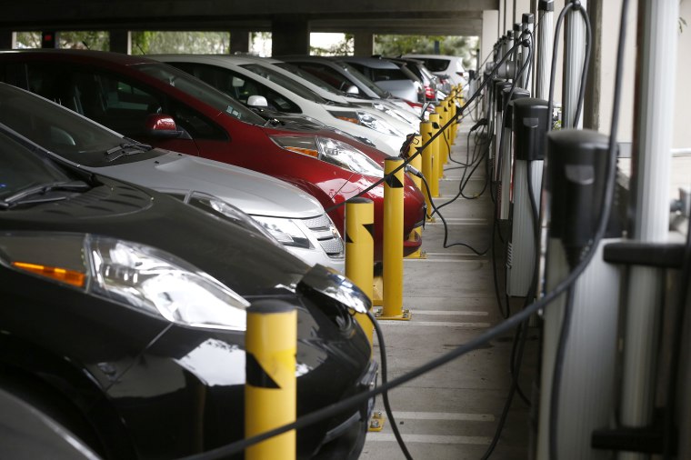 Electric cars sit charging in a parking garage at the University of California, Irvine