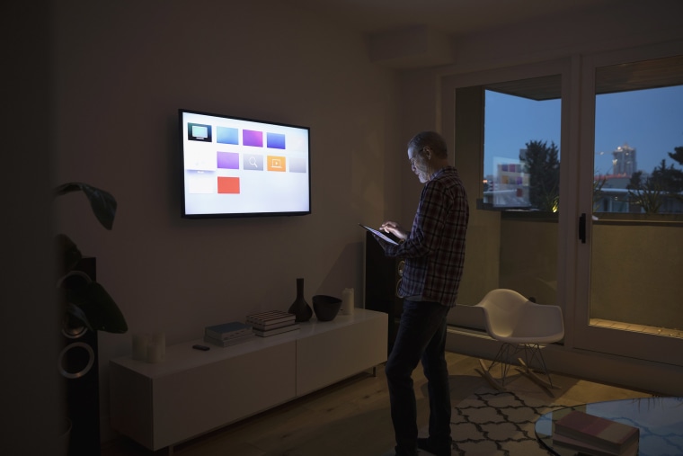 Image: A man using smart TV apps via a digital tablet.