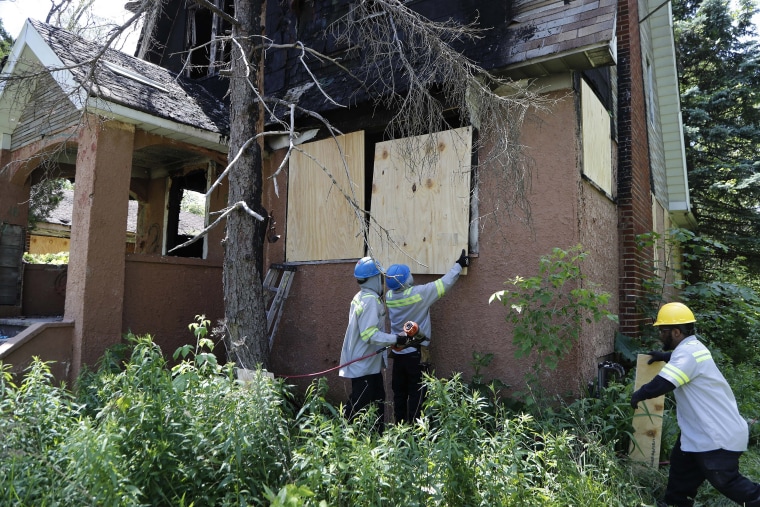 Image: Members of the Detroit's Board Up Brigade board up a vacant home in north Detroit