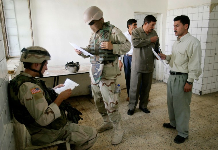 US soldier checks workers' list during a patrol in Arij, northern Iraq.