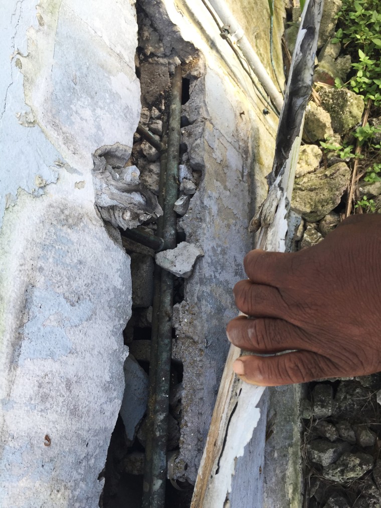 The back wall of Romeo Smith's house has crumbled, exposing the metal rebar.