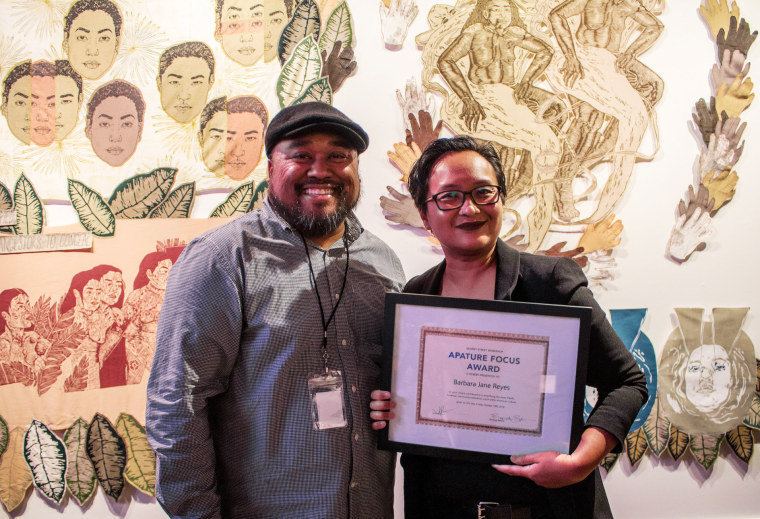 Jason Bayani, left, presents an APATURE focus award to Barbara Jane Reyes