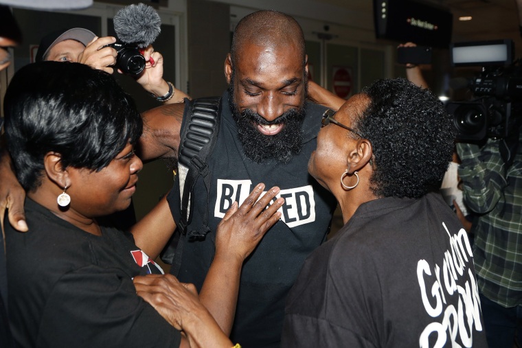 Image: Wendell Brown hugs relatives after his arrival at the Detroit Metropolitan Airport