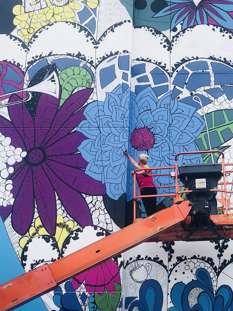 Street artist Kelsey Montague working on a mural.