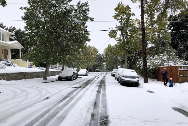 Image: Pedestrians walk along a snow covered street in Helena, Mont., on Sept. 29, 2019.