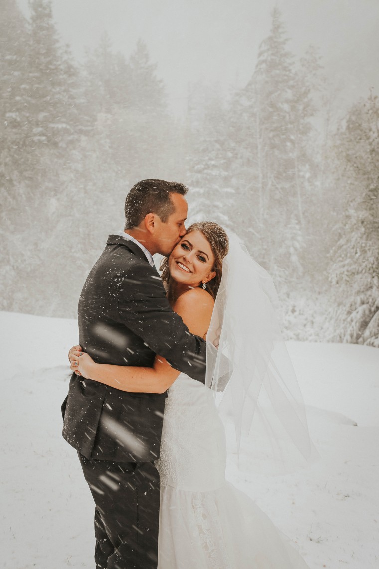 Newlyweds pose for wedding photos in snowstorm