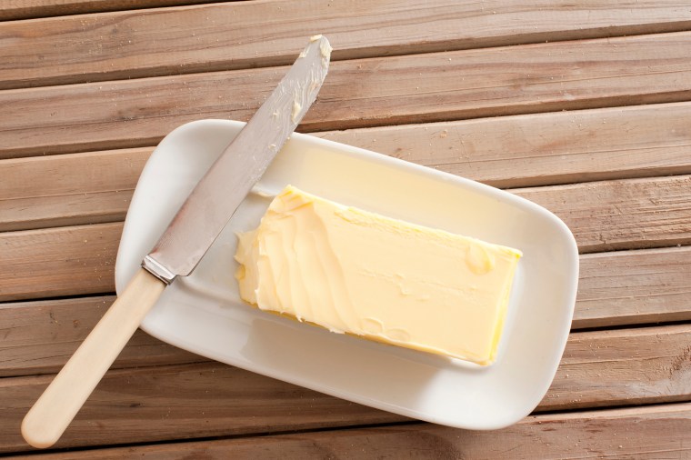 Butter And Knife On Wooden Table