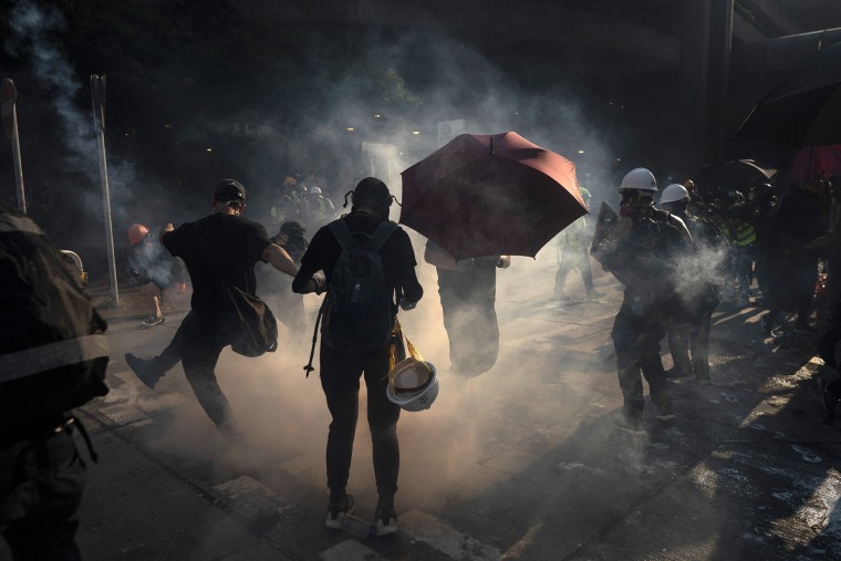 Image: A protestor kicks back an exploded tear gas shell in Hong Kong