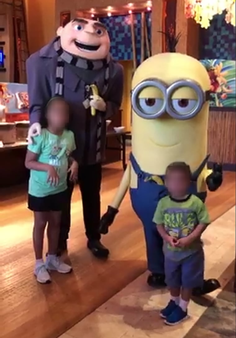 A Universal Orlando employee dressed as the character Gru from "Despicable Me" makes an 'OK' symbol on the Zingers' then 6-year-old biracial daughter's shoulder.