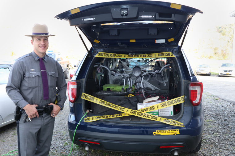 Frank Abbott, 29, stands in front of a car stuffed with Halloween decorations and candy for children at a local church in Binghamton, NY. Abbott dreamed of becoming a New York State Trooper since he was 12 years old. "I wanted to serve," he said. "I wanted to help."