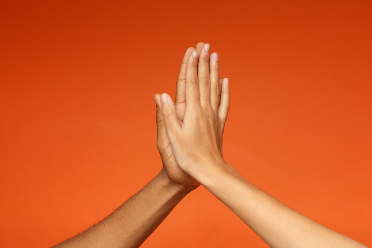 Man and woman greeting each other with high five