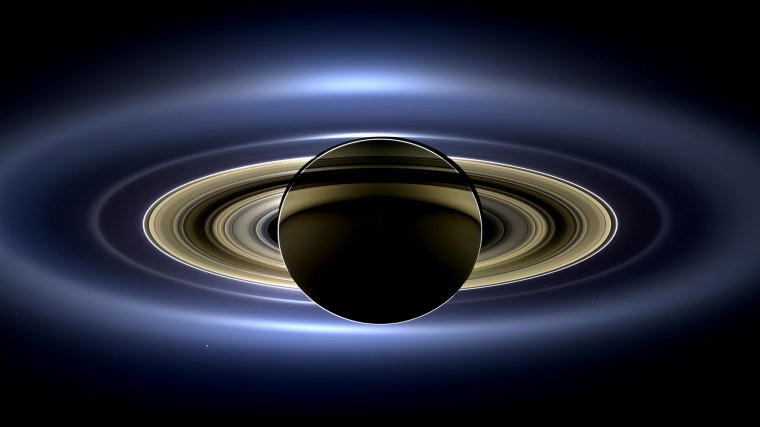 Image: On July 19, 2013, NASA's Cassini spacecraft slipped into Saturn's shadow and turned to image the planet, seven of its moons, its inner rings, and, in the background, our home planet, Earth.