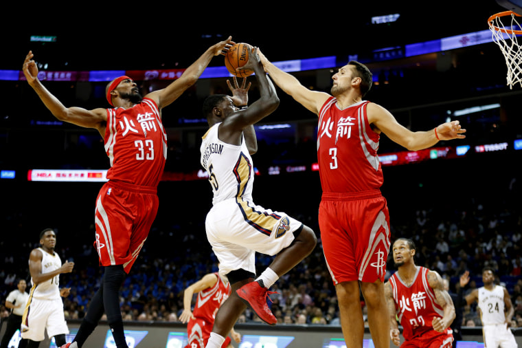IMage: Houston Rockets' Corey Brewer, left, and Ryan Anderson attempt to block New Orleans Pelicans' player Lance Stephenson during an exhibition game in Shanghai in 2016.