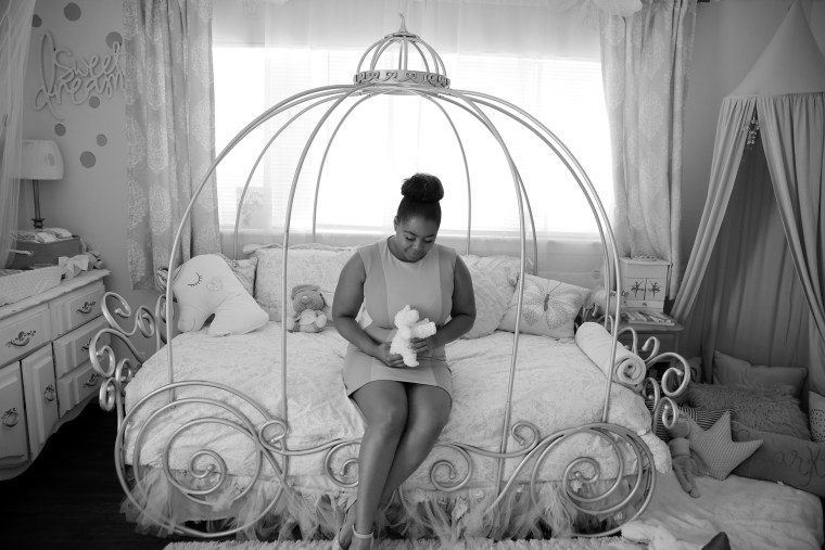 Ajshay James sits on her daughter's bed. The stuffed lamb is bigger than Harper was when she was born.