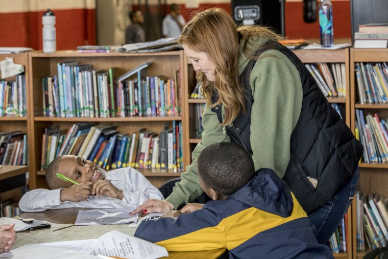 Secondary education specialist Amy Mullins works with students at the gym.