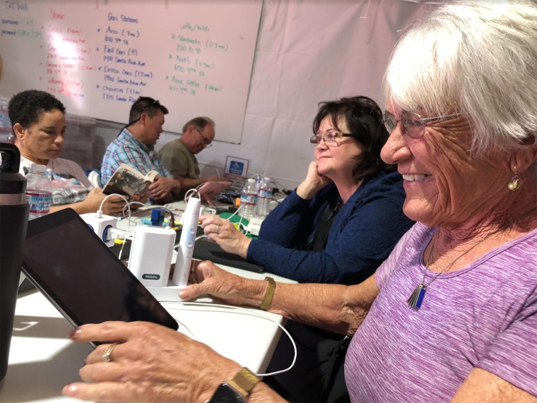 Inga Torok, 75, a retired California state employee, charges her phone, tablet and electronic toothbrush during a blackout at a temporary community center run by utility PG&amp;E, on Thursday.