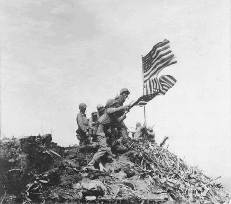 Pvt. Bob Campbell's shot of the first flag being lowered as the second is raised.