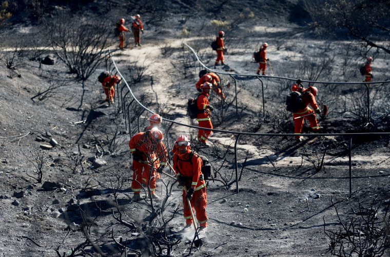 Image: An inmate firefighter crew extinguishes hot spots from the Saddleridge Fire in Porter Ranch, Calif., on Oct. 12, 2019.