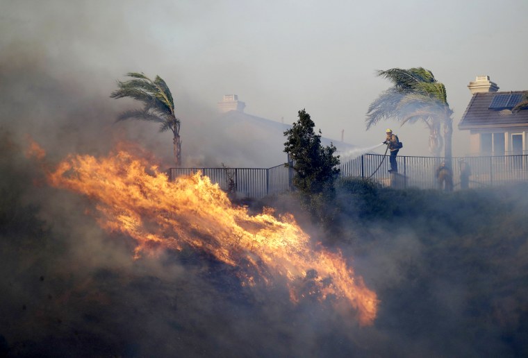 Image: A firefighter works to extinguish an advancing wildfire in Porter Ranch, Calif., on Oct. 11, 2019.