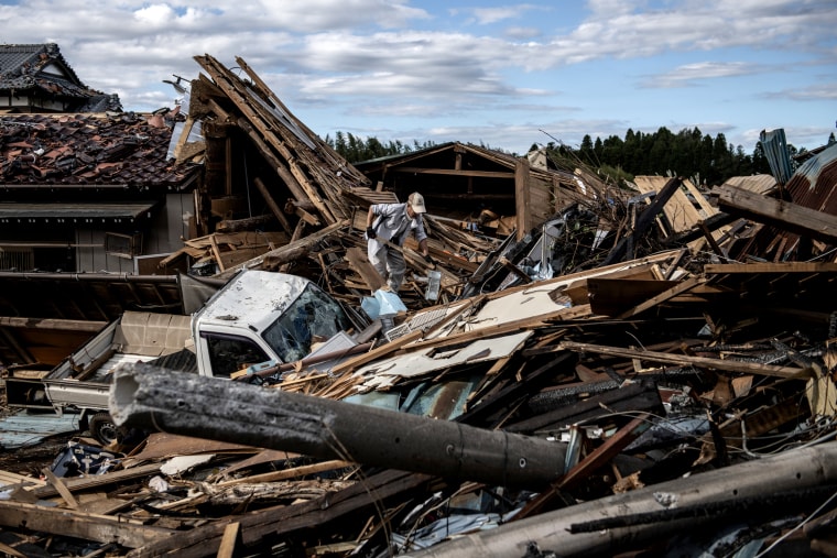 Image: A man looks through debris of a building that was destroyed by a tornado shortly before the arrival of Typhoon Hagibis in Chiba, Japan, on Oct. 13, 2019.