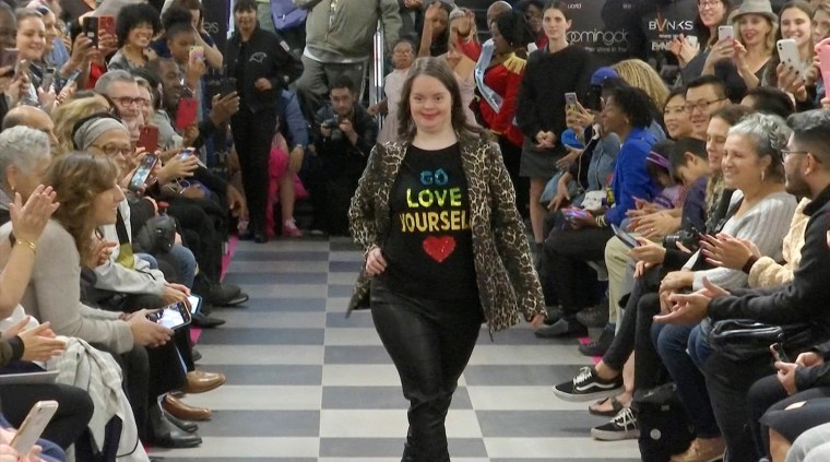 A young girl walks the runway in a statement T-shirt at "Gigi's Playhouse Fashion Show" in New York.