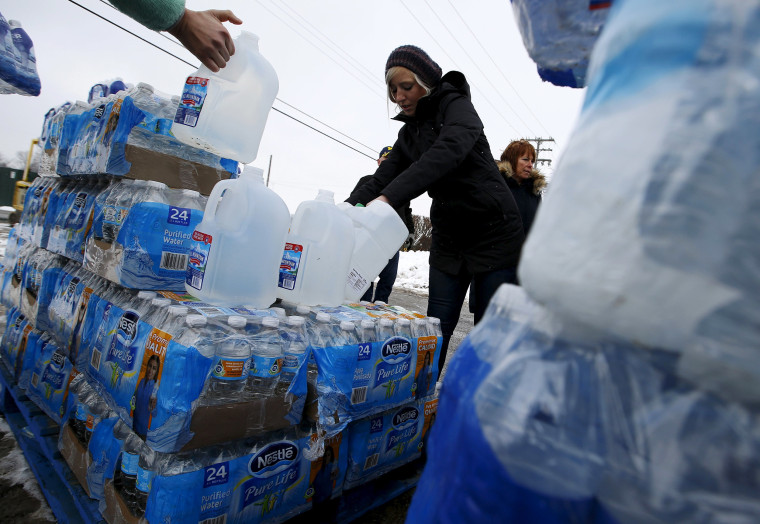 Image: Volunteers distribute bottled water to help combat the effects of the crisis when the city's drinking water became contaminated with dangerously high levels of lead in Flint