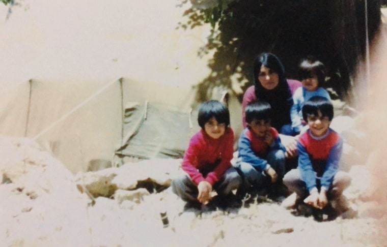 Yerevan Adham, left, is shown with his mother and three brothers at a refugee camp in Iran in 1987.