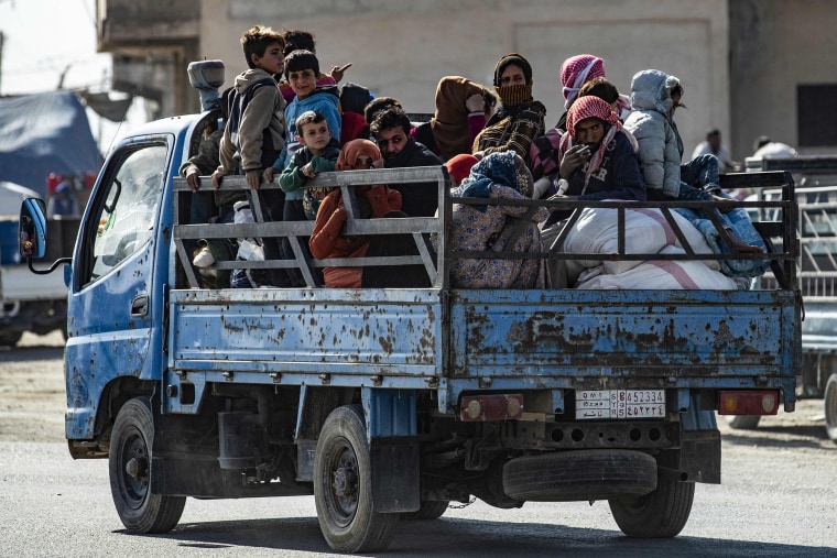 Image: Syrian families fleeing the battle zone between Turkey-led forces and Kurdish fighters from the Syrian Democratic Forces (SDF) in and around the northern flashpoint town of Ras al-Ain, arrive in the city of Tal Tamr