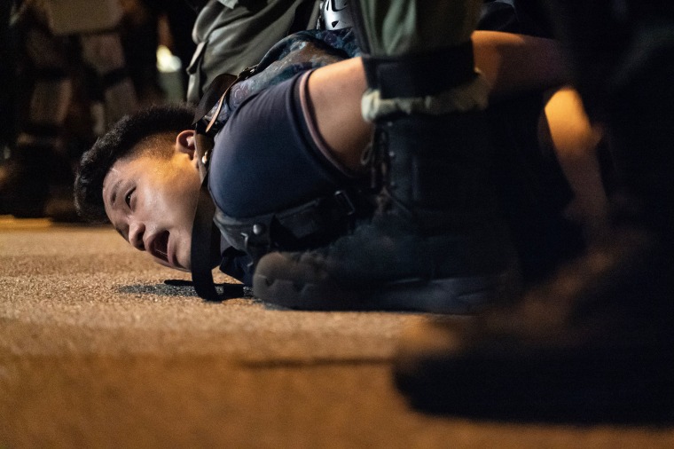 Image: A pro-democracy protester is arrested by riot police during a rally in Central district