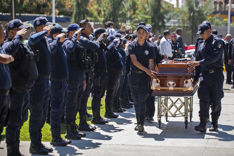Police officers pay tribute to their colleagues on Oct. 15, 2019, to their colleagues killed in an ambush the day before in the Mexican state of Michoacan.