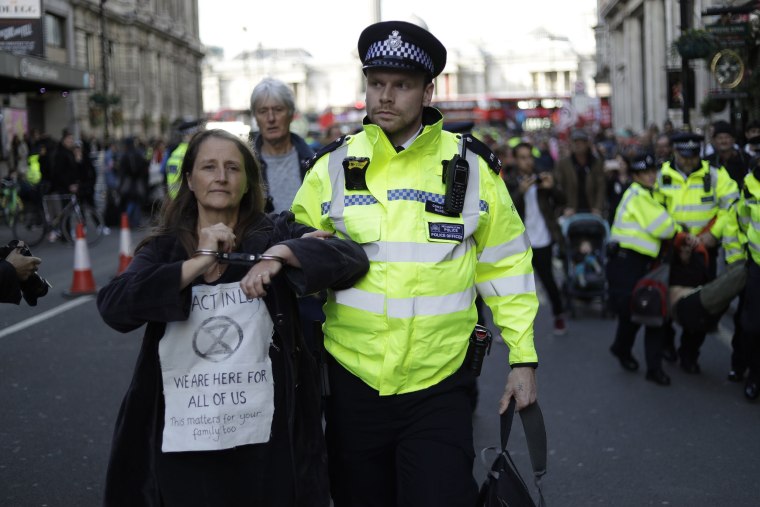 Image: Police officers remove Extinction Rebellion climate change protesters who sat and blocked traffic on Whitehall at the bottom of Trafalgar Square