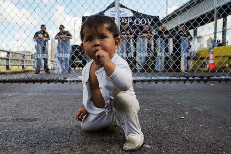Image: A Mexican baby is seen in front of the gates to the Gateway International Bridge in Matamoros