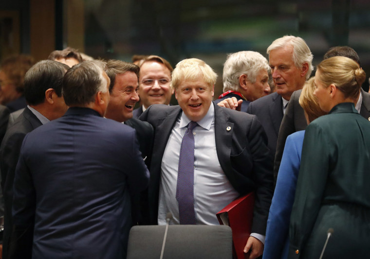 Image: British Prime Minister Boris Johnson, center, is greeted by Luxembourg's Prime Minister Xavier Bettel, center left, during a round table meeting at an EU summit in Brussels