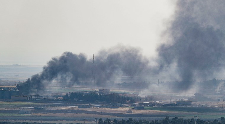 Smoke rises over the Syrian town of Ras al-Ain, as seen from across the border in Ceylanpinar, Turkey, on Oct. 18, 2019.