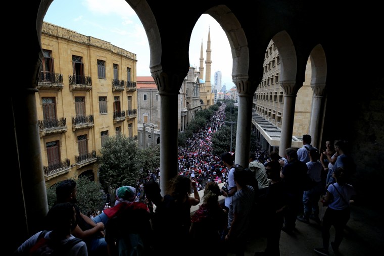 Image: Demonstrators watch crowds from a balcony during anti-government protests in Beirut, Lebanon, on Oct. 20, 2019.