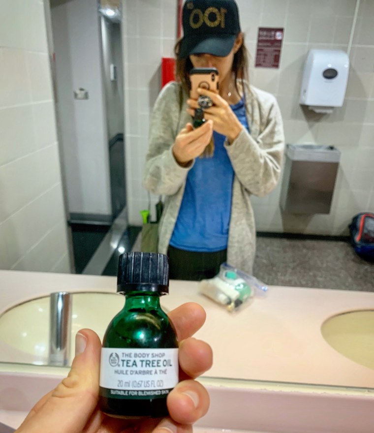 Adding tea tree oil to my moisturizer in the airport in Taipei