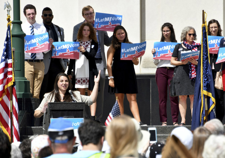 Image: Katie Fahey talks to demonstrators as they rally outside the Michigan Hall of Justice