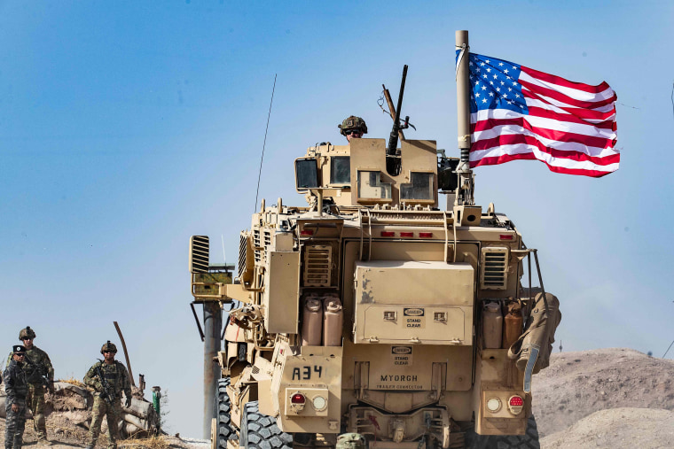 Image: A U.S. soldier sits atop an armoured vehicle during a demonstration by Syrian Kurds against Turkish threats at a US-led international coalition base on the outskirts of Ras al-Ain town in Syria's Hasakeh province near the Turkish border