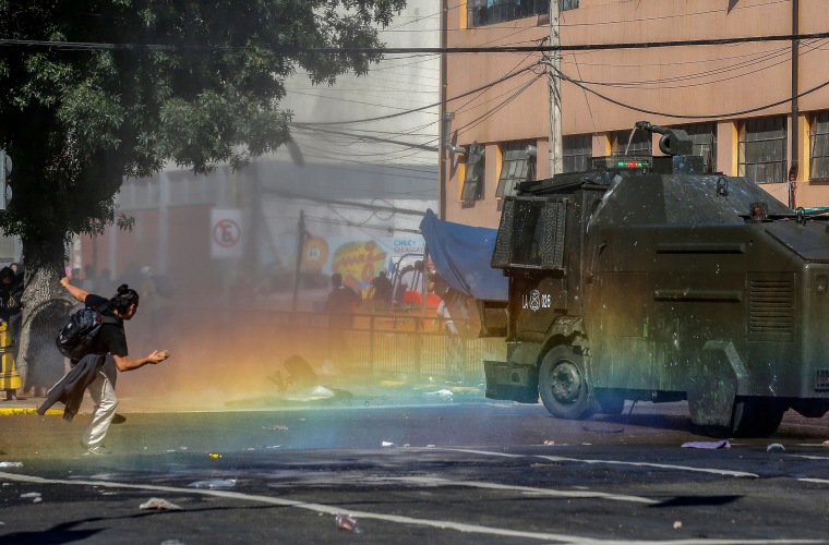 Image: A demonstrator clashes with riot police during protests in Valparaiso, Chile