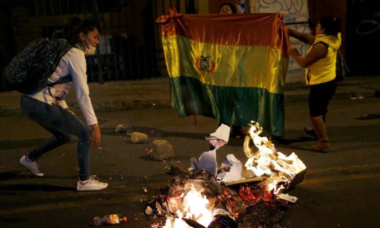 Image: Protesters burn campaign posters of the ruling party outside the Supreme Electoral Court in La Paz, Bolivia, on Oct. 21, 2019.