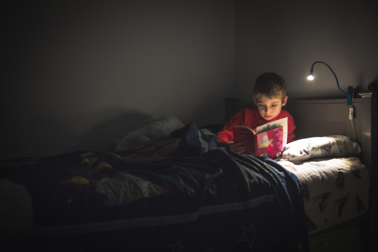 Image: Boy reading in bed
