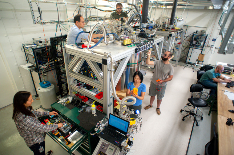 Scientists and engineers at Google maintaining a refrigerator that houses the chip used to demonstrate the quantum supremacy experiment. Clockwise from top: Anthony Megrant, Ted White, Andrew Dunsworth (far right), Jaime Yao, Brian Burkett, Ping Yeh.