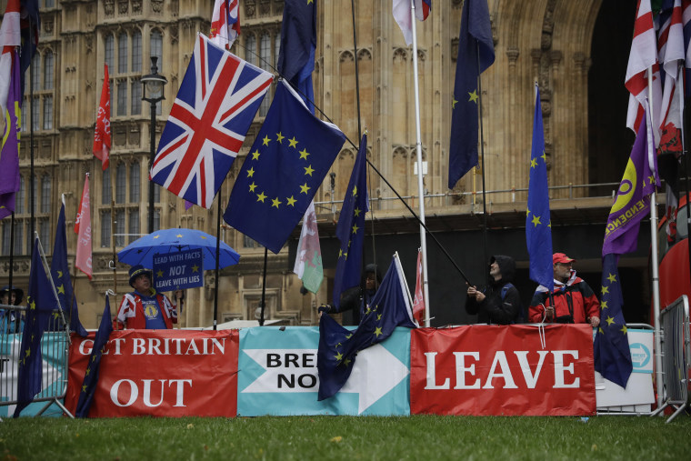 Anti-Brexit remain in the European Union supporter Steve Bray, left, protests next to banners placed by pro-Brexit leave the EU supporters.