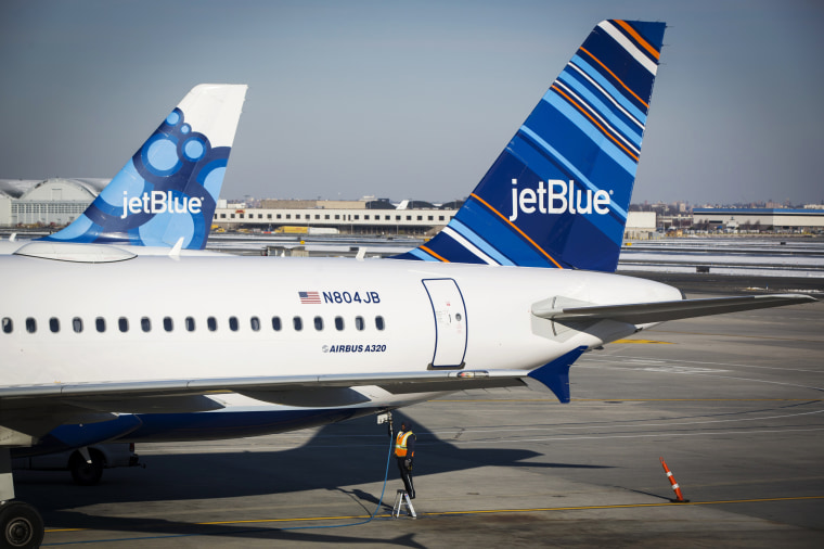 An airport worker fuels a JetBlue plane on the tarmac of the John F. Kennedy International Airport in New York