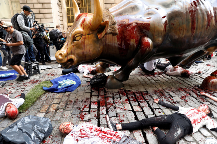 Image: Climate change activists protest at the Wall Street Bull in Lower Manhattan during Extinction Rebellion protests in New York City