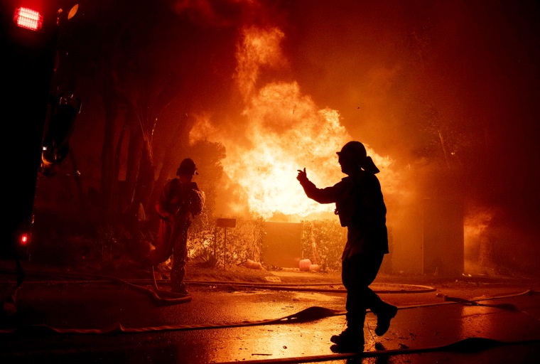 Image: Firefighters work to save a home overtaken by the Getty Fire on Tigertail Road in Los Angeles on Oct. 28, 2019.