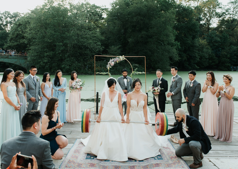 Zeena Hernandez, left, and Lisa Yang, deadlift a 253 pound barbell during their wedding ceremony in Prospect Park