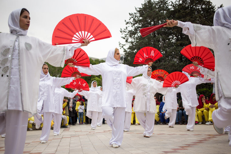 Doost, center, performs a fan form routine with fellow tai chi coaches in Niavaran Park in Tehran on April 27, 2018.