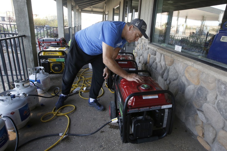 Image: Brian Boyd checks one of the generators used to provide power at the Clear Creek Crossing store near Paradise